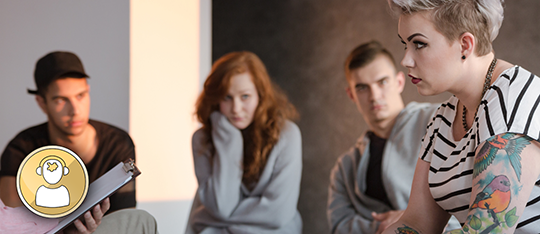 Four young adults seated with a researcher holding a clipboard.