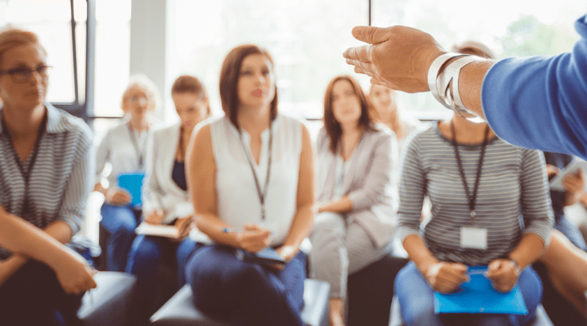 Members of the public listening and taking notes during a public talk from a medical professional